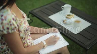 <strong>一</strong>个穿睡衣的漂亮女人在外面吃早餐，在她腿上的纸上写了<strong>一封信</strong>。